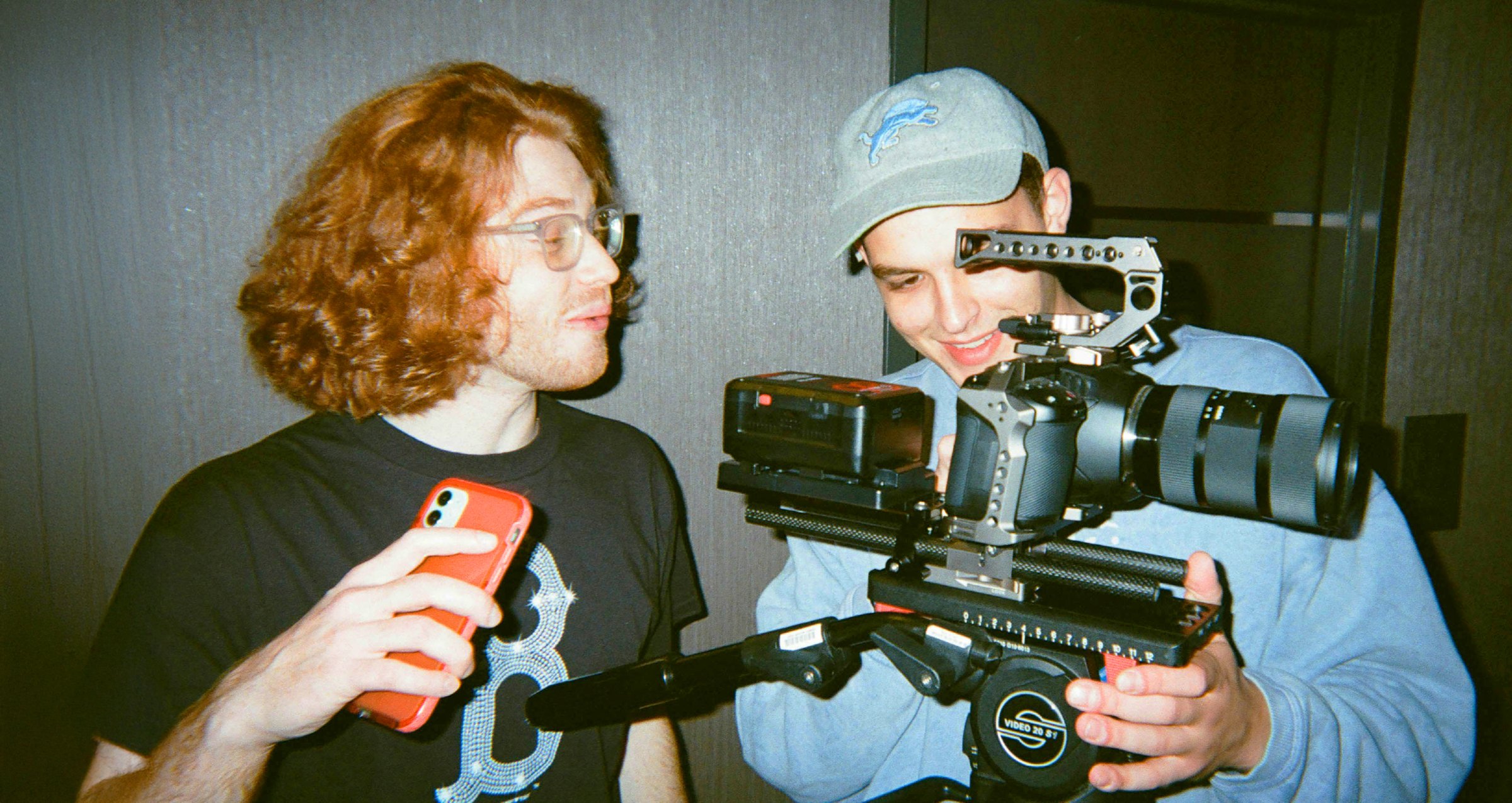 A film crew shooting in a studio, surrounded by lighting rigs and monitors.