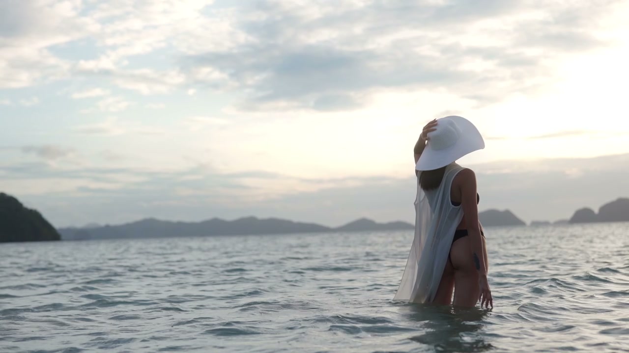 Милая морячка стоя в море ловит кайф