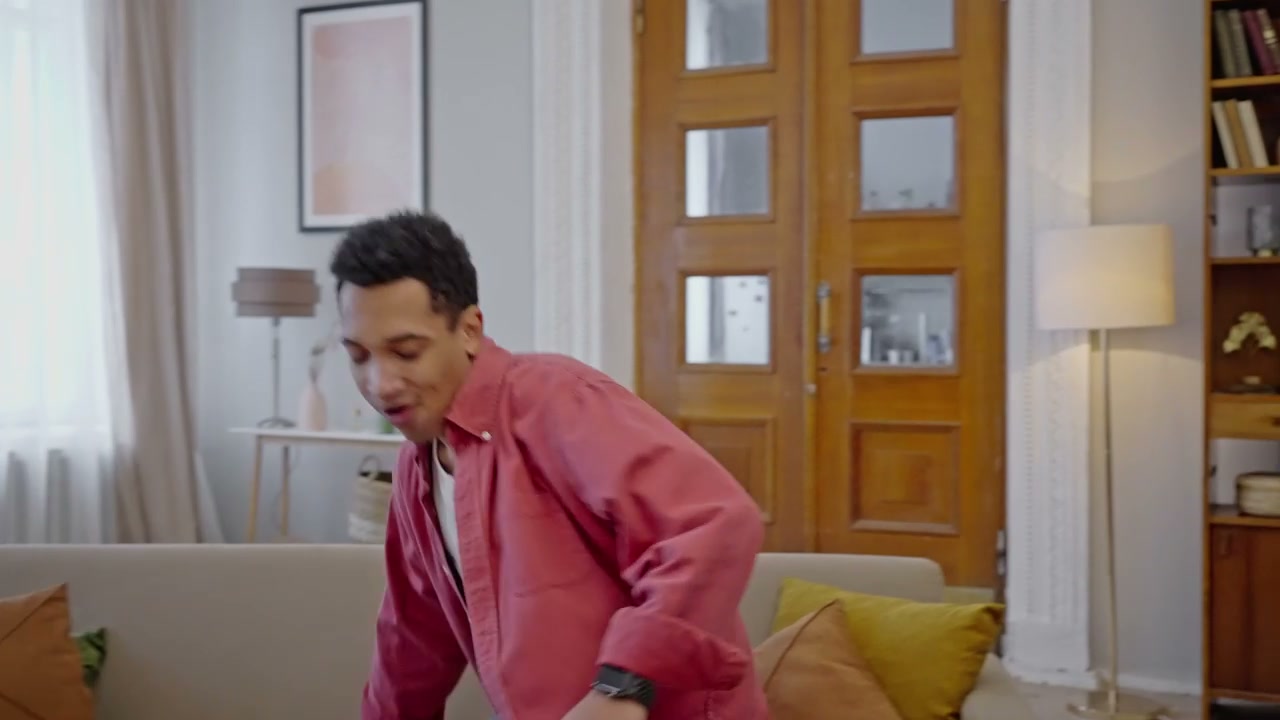 Cheerful Man Using Laptop on Sofa