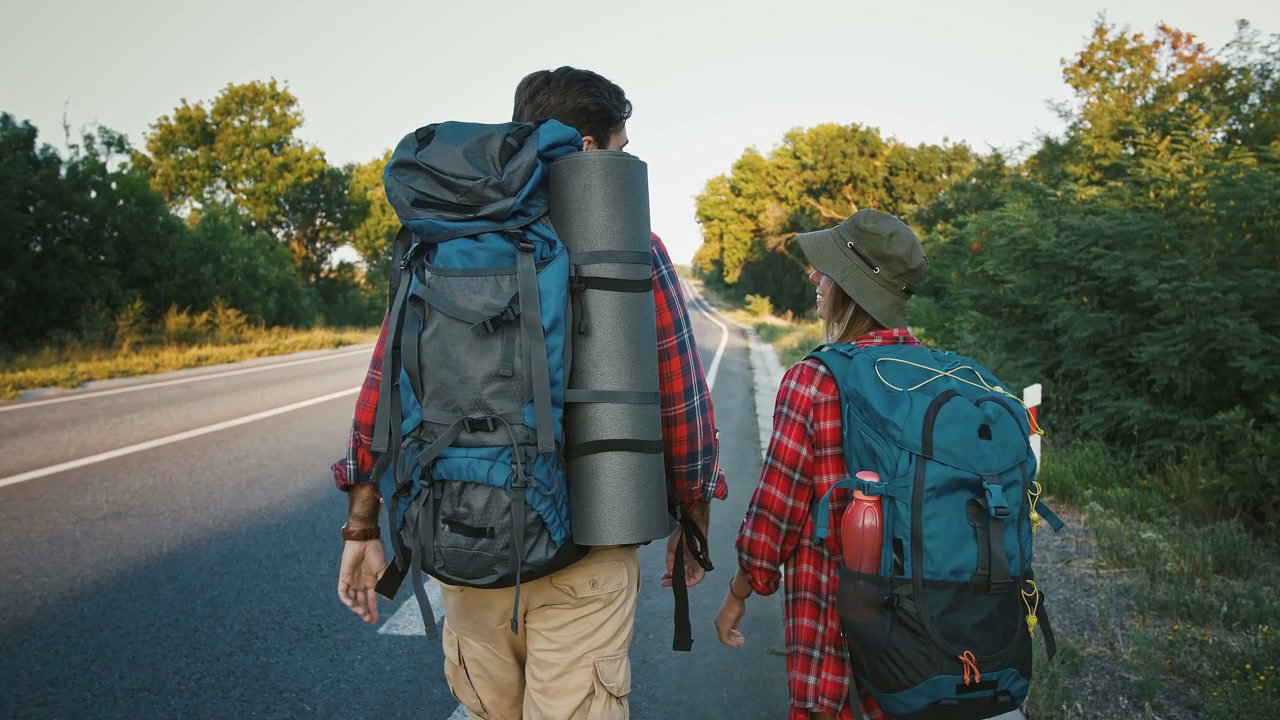 Hikers With Backpacks Walking on Road