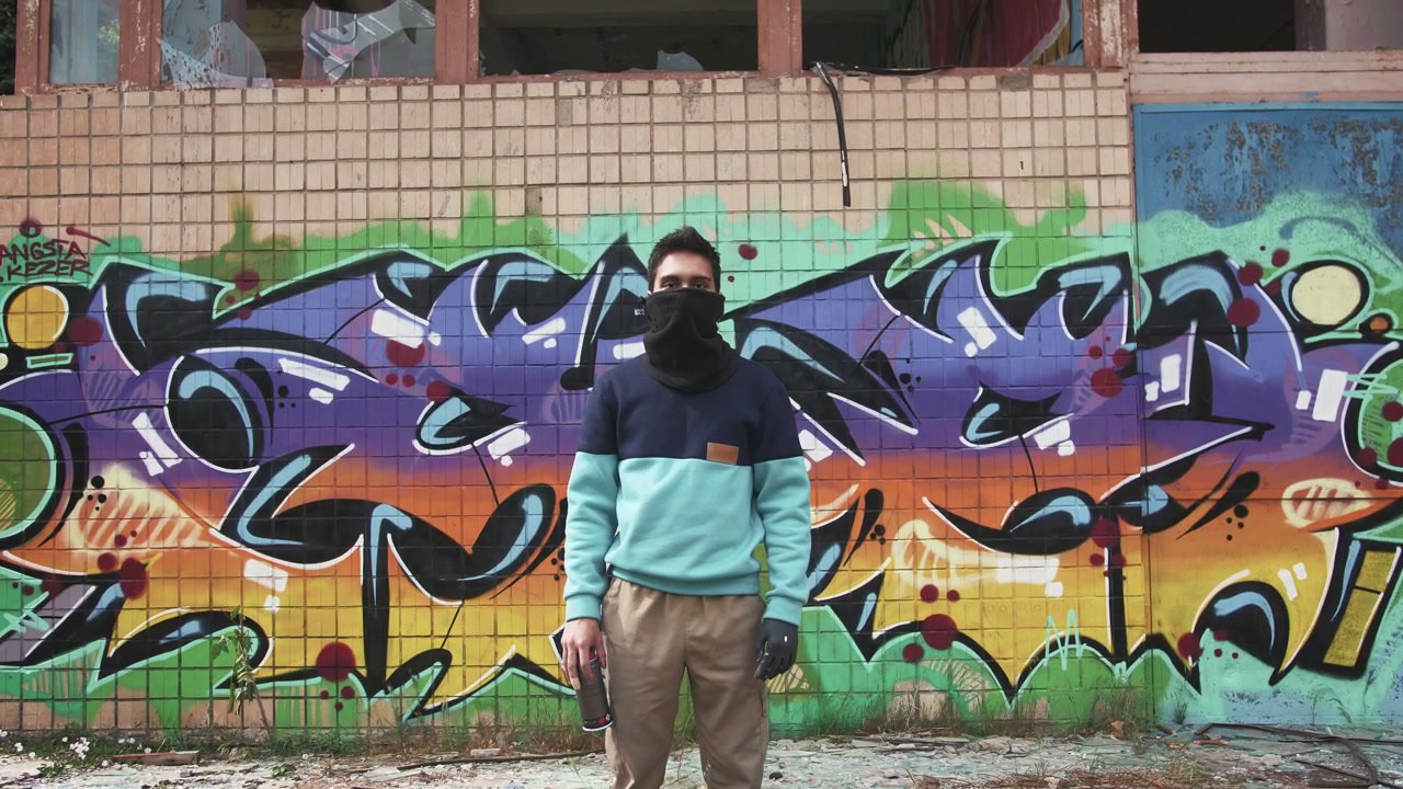 Graffiti Artist Standing Against Mural