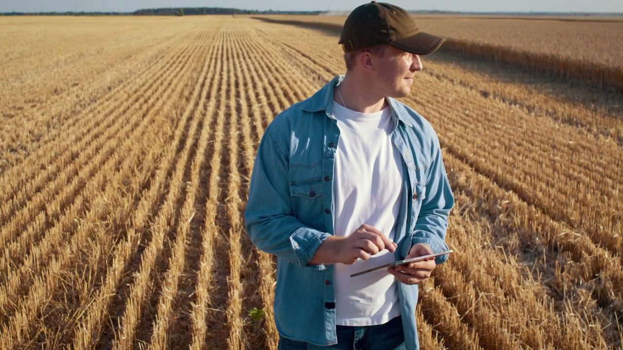 Farmer Using Tablet in Harvested Field