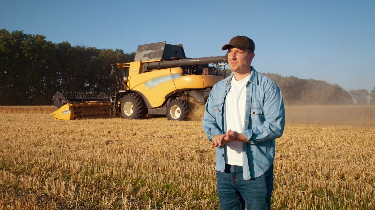 Farmer Observing Combine Harvester in Field
