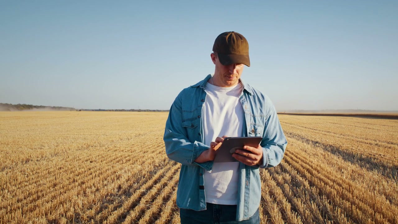 Farmer Using Tablet in Harvested Field