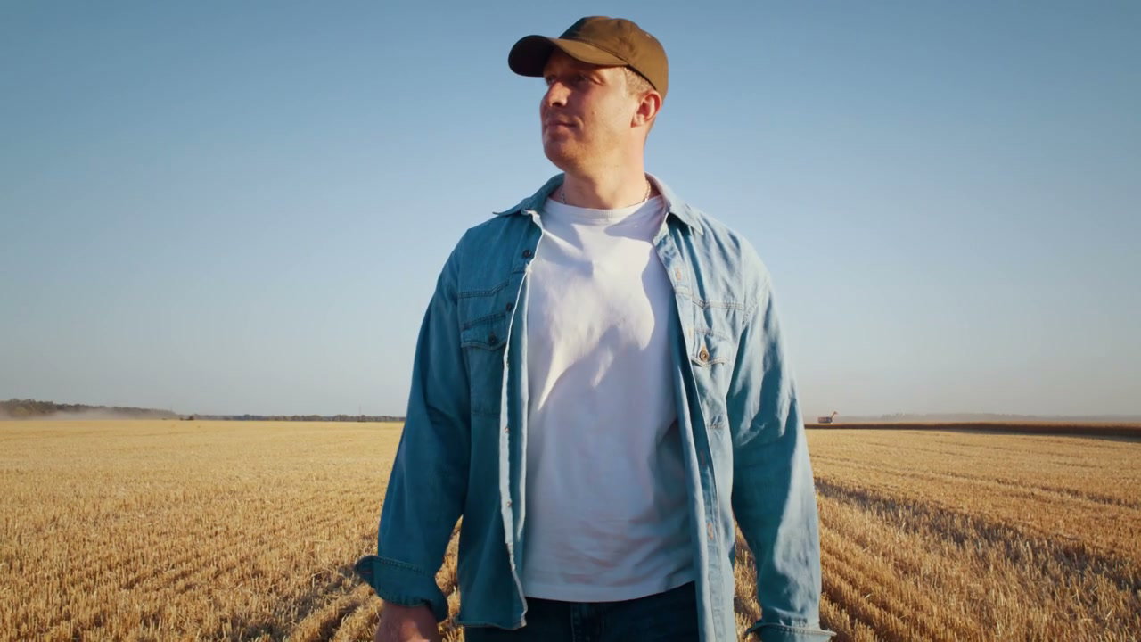 Farmer Walking in Harvested Wheat Field with Tablet