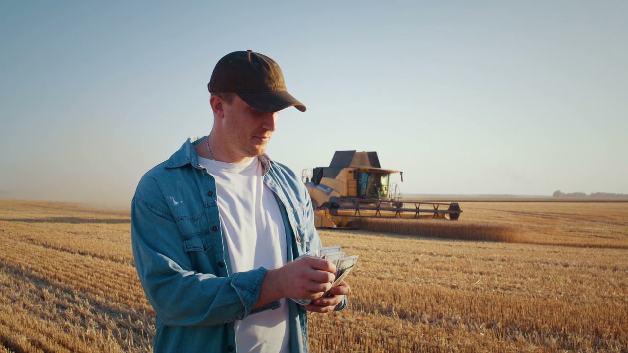 Farmer Counting Money in Harvested Field