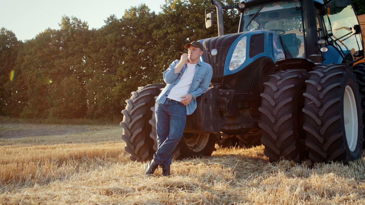Farmer Resting by Tractor at Sunset