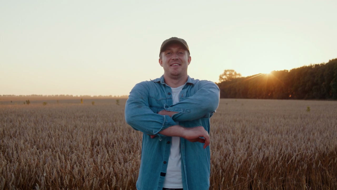 Smiling Farmer Crossing Arms in Wheat Field