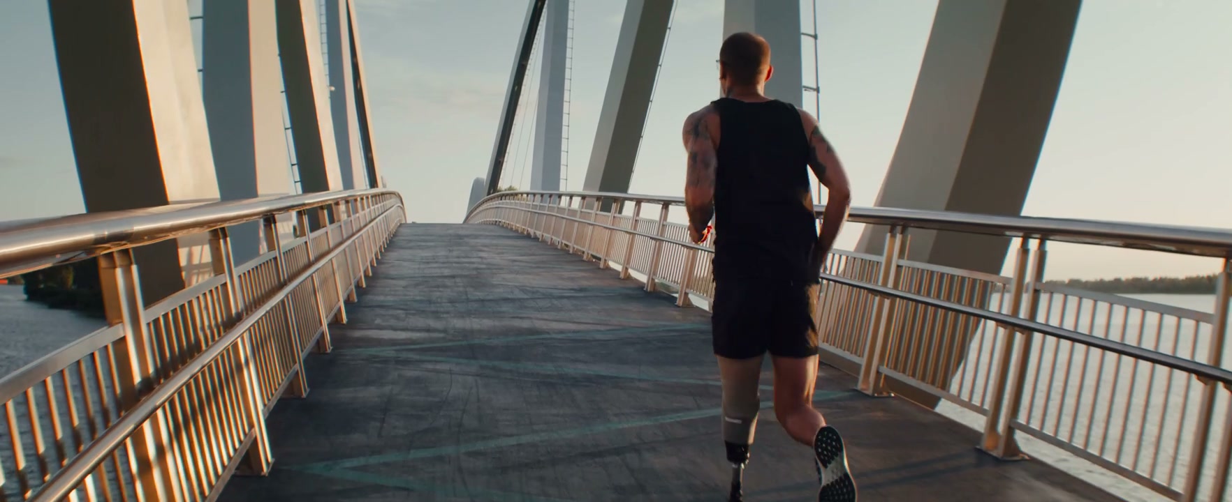Man with Prosthetic Leg Running on Bridge