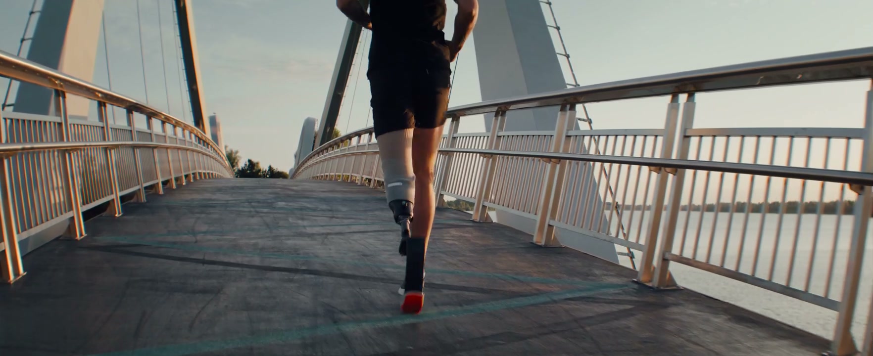 Runner With Prosthetic Leg On Modern Bridge