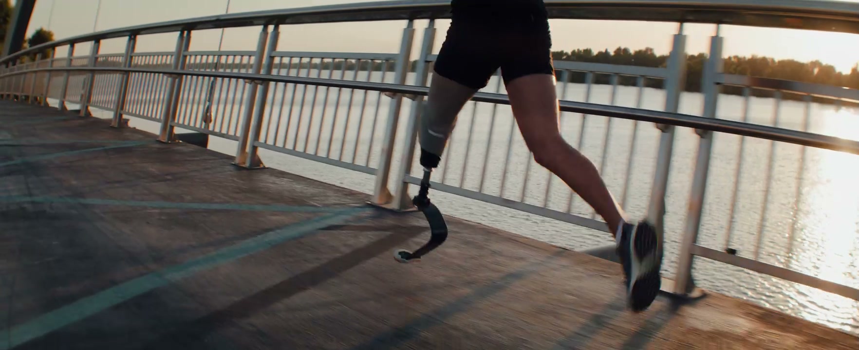 Runner with Prosthetic Leg Jogging on Bridge