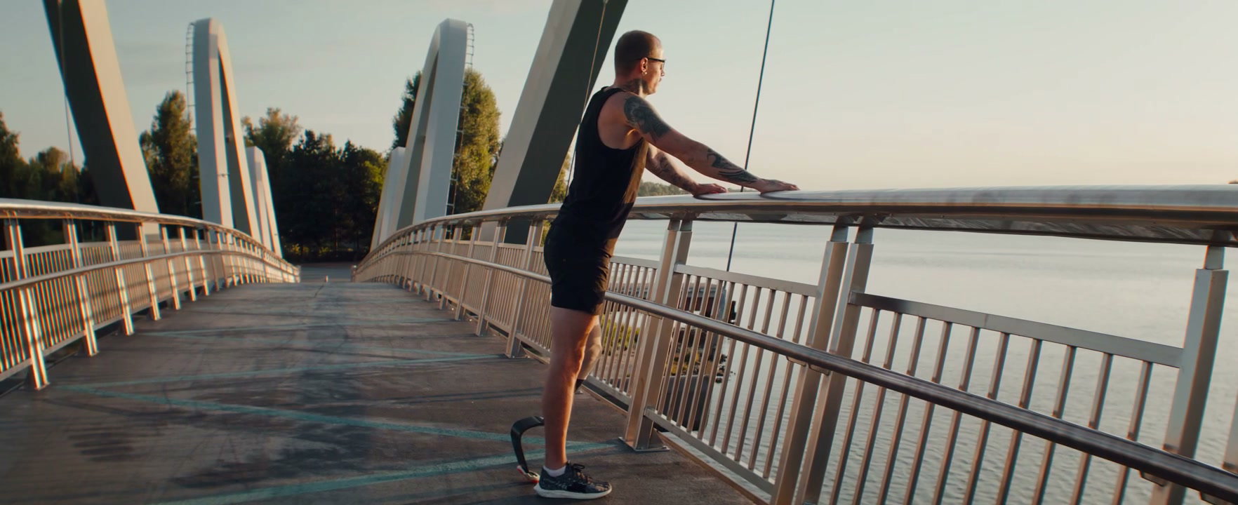 Adaptive Runner Stretching on Bridge at Sunrise