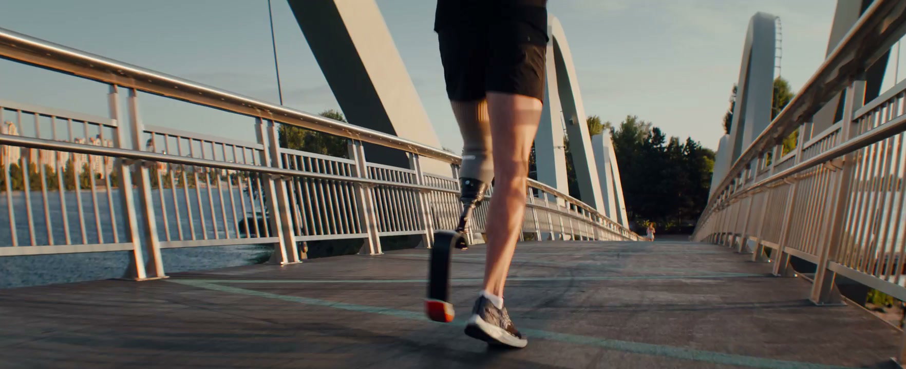 Person with Prosthetic Leg Running on Bridge at Golden Hour