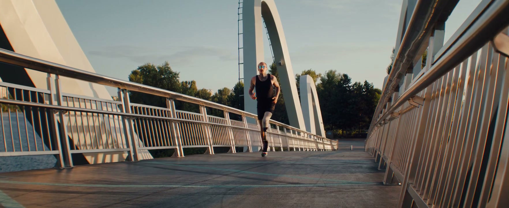 Man with Prosthetic Leg Running on Modern Bridge