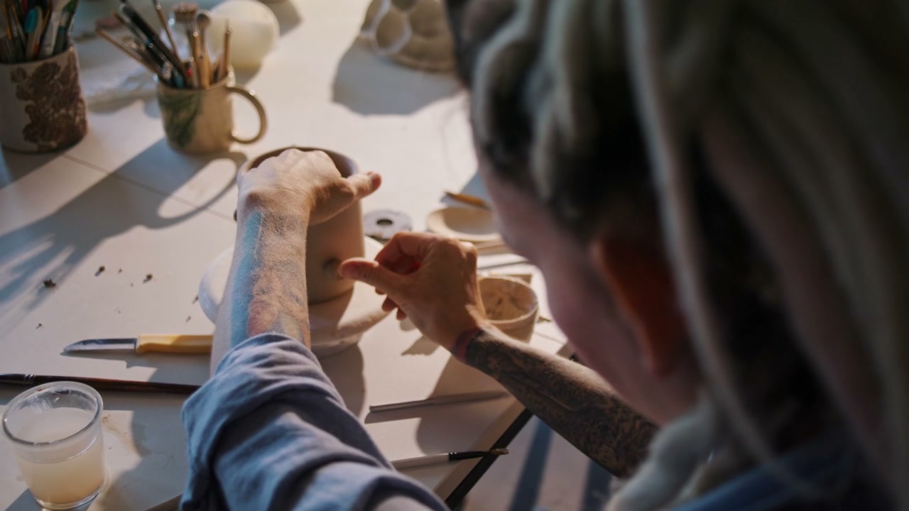 Artist Decorating Clay Mug in Ceramic Studio