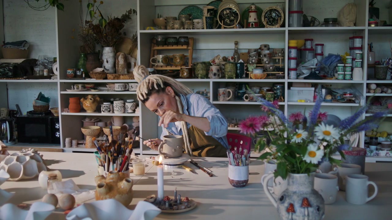 Woman Decorating Ceramic Mug in Studio
