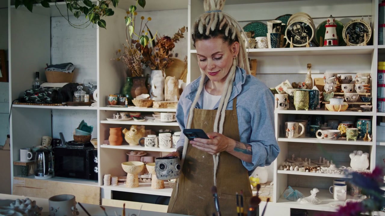 Artisan Using Smartphone in Ceramic Studio