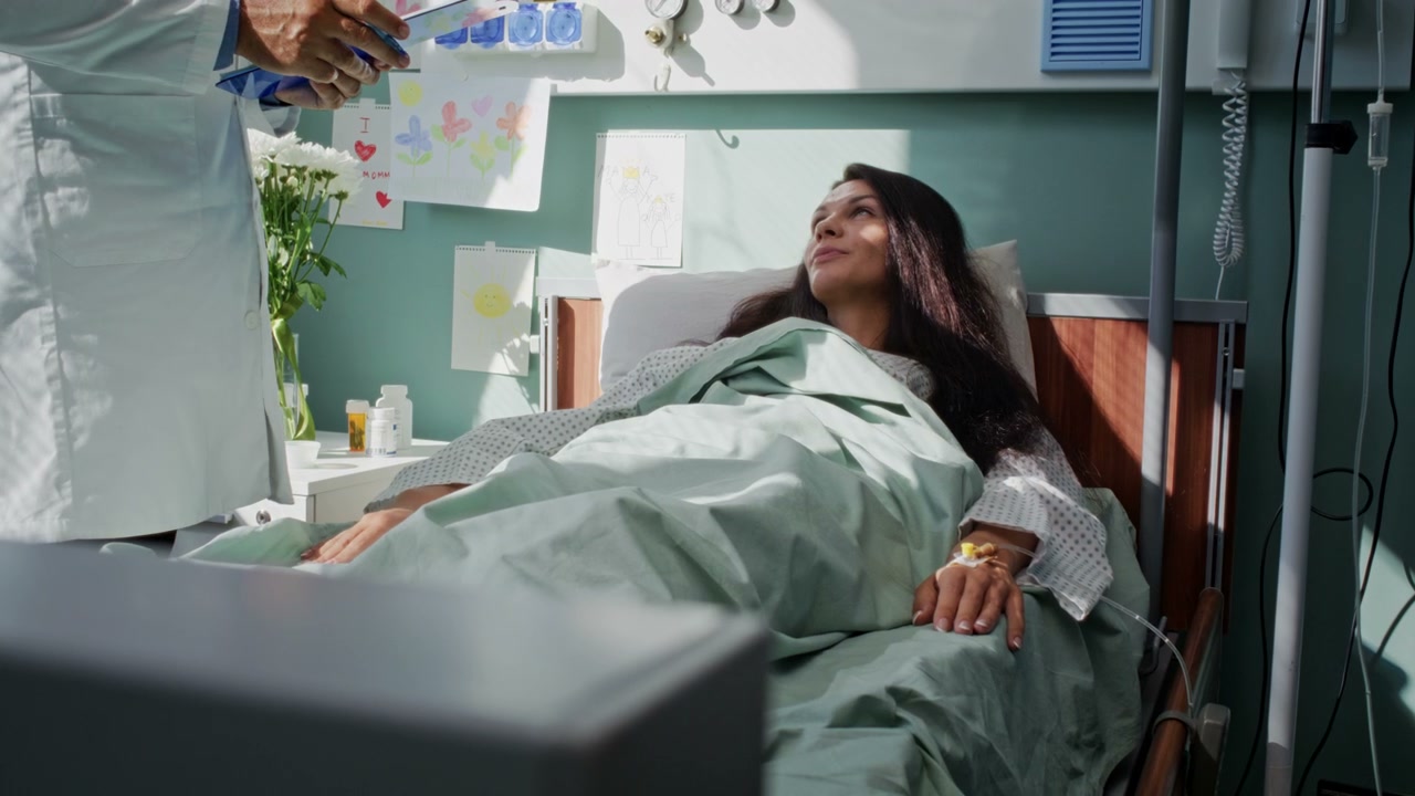 Doctor Discussing with Patient in Hospital Bed