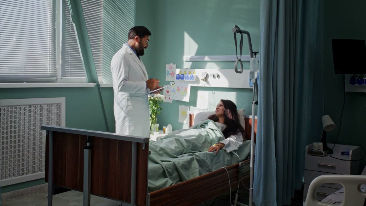 Doctor Consults Woman Patient in Hospital Room