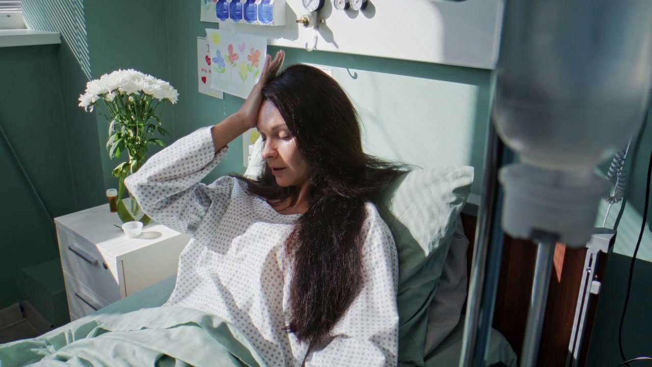 Woman Patient With Headache in Hospital Bed
