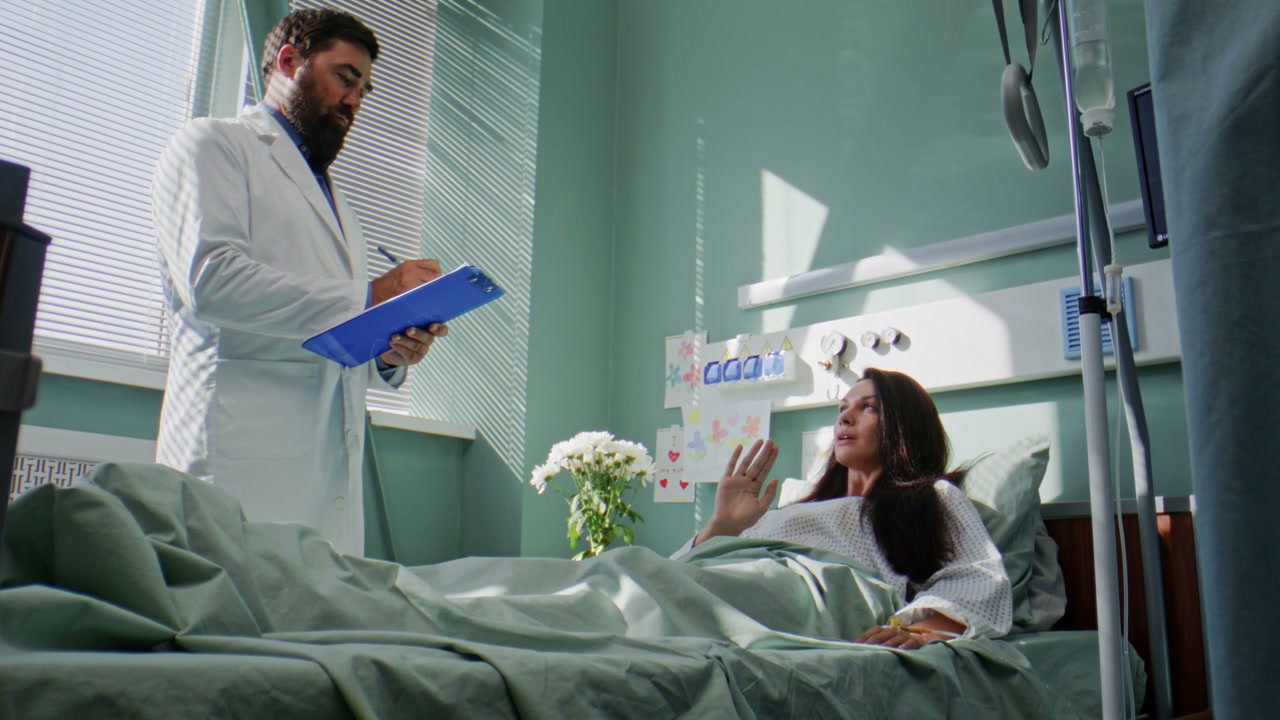 Doctor Consults Patient in Hospital Room