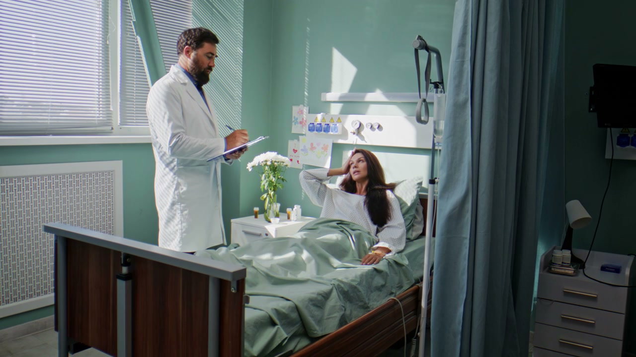 Doctor Talking to Woman in Hospital Bed
