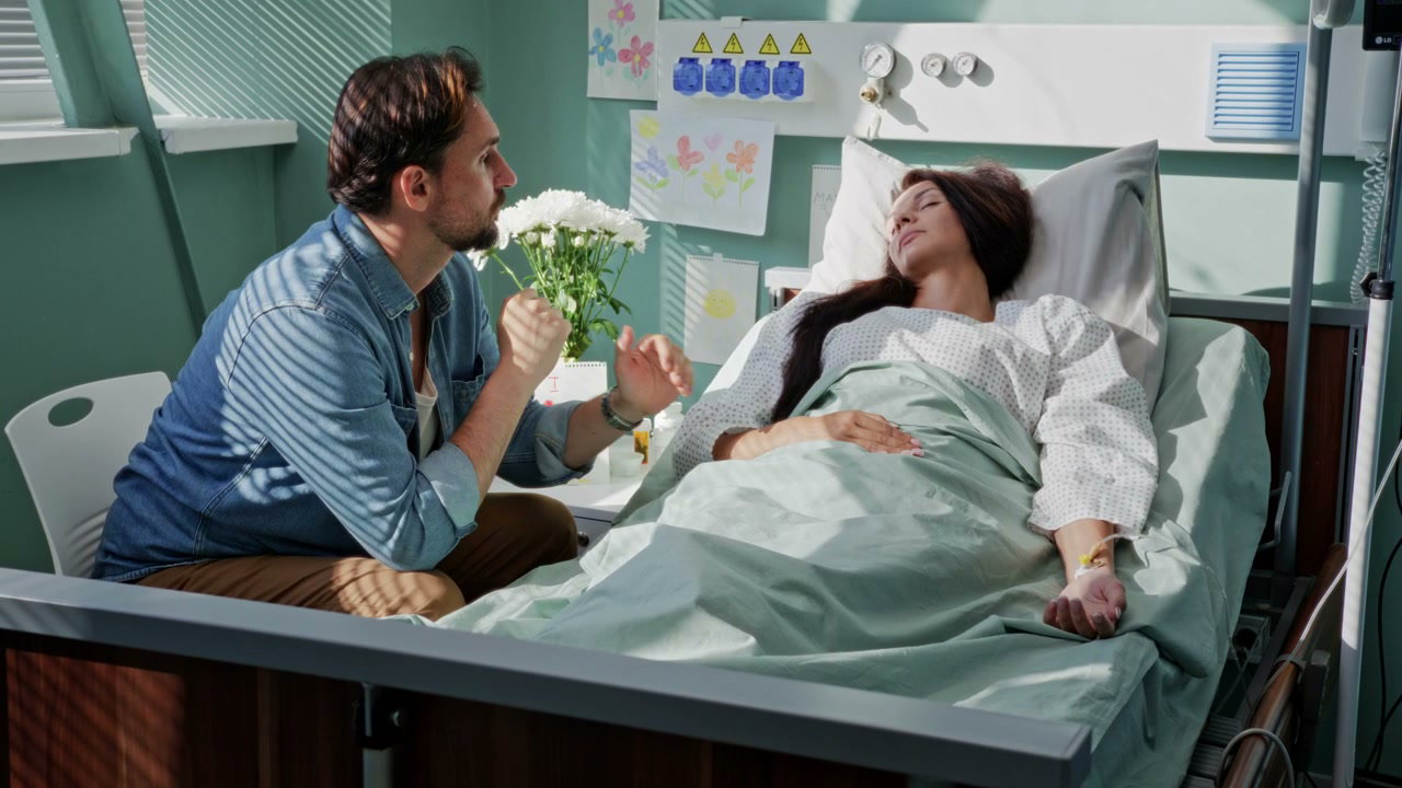 Man Comforting Woman in Hospital Bed