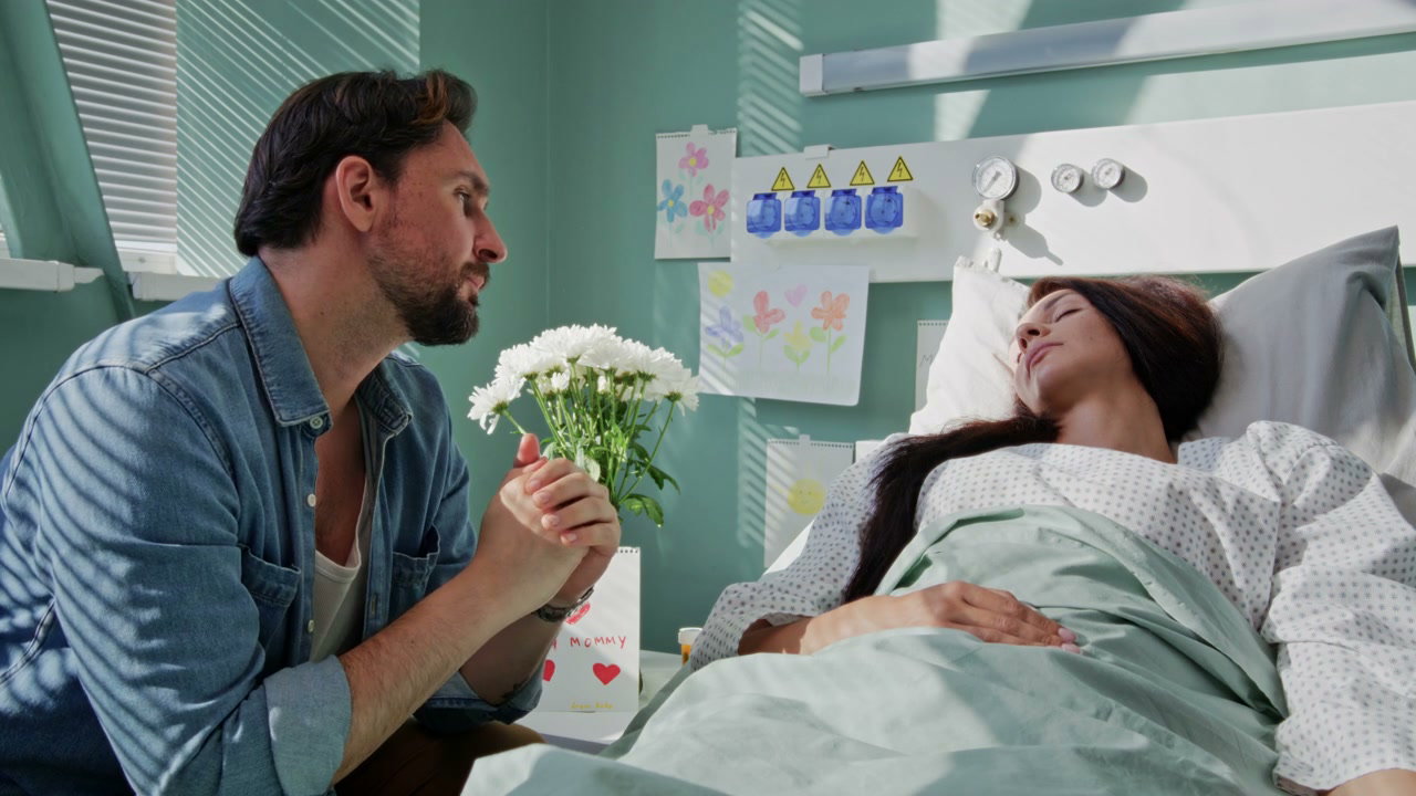 Man Comforts Partner in Hospital Bed