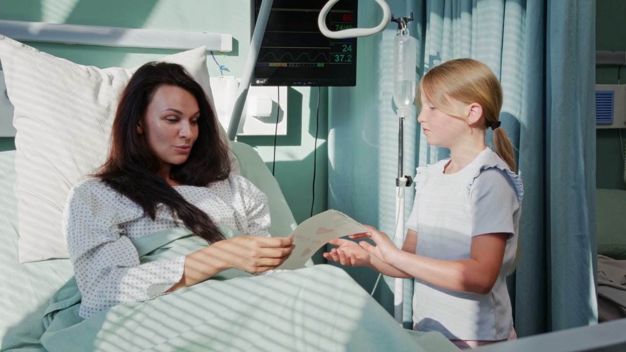 Daughter Gives Card to Mother in Hospital Bed