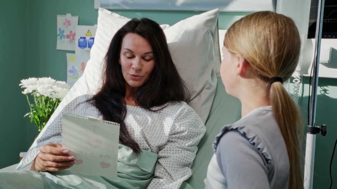 Daughter Gives Card to Mother in Hospital Bed