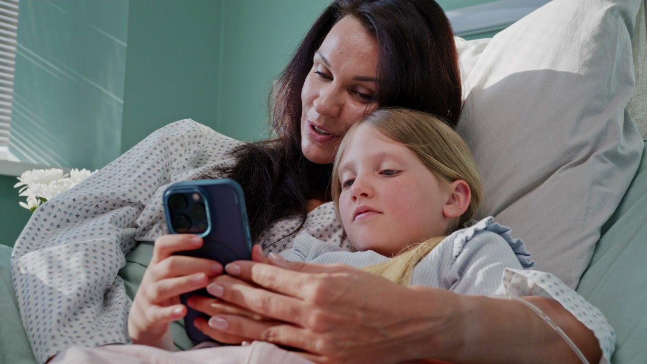 Mother and Child Share Phone in Hospital Bed
