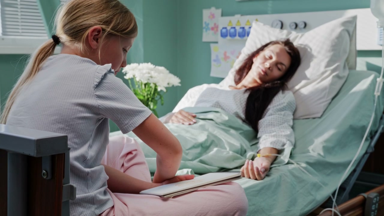 Girl Drawing While Mother Rests in Hospital Bed