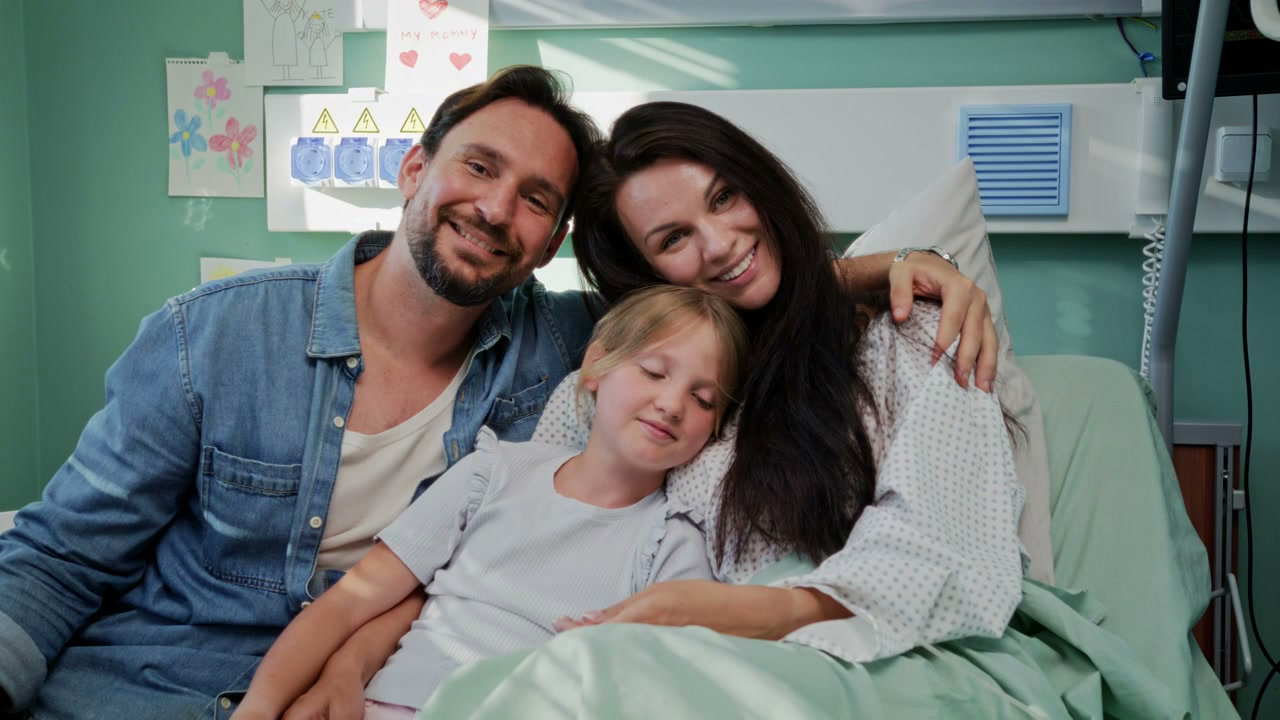 Smiling Family in Hospital Room