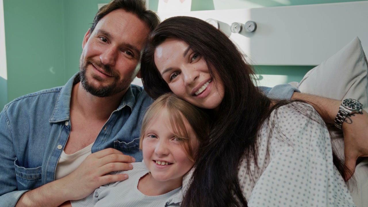 Happy Family Embracing in Hospital Bed