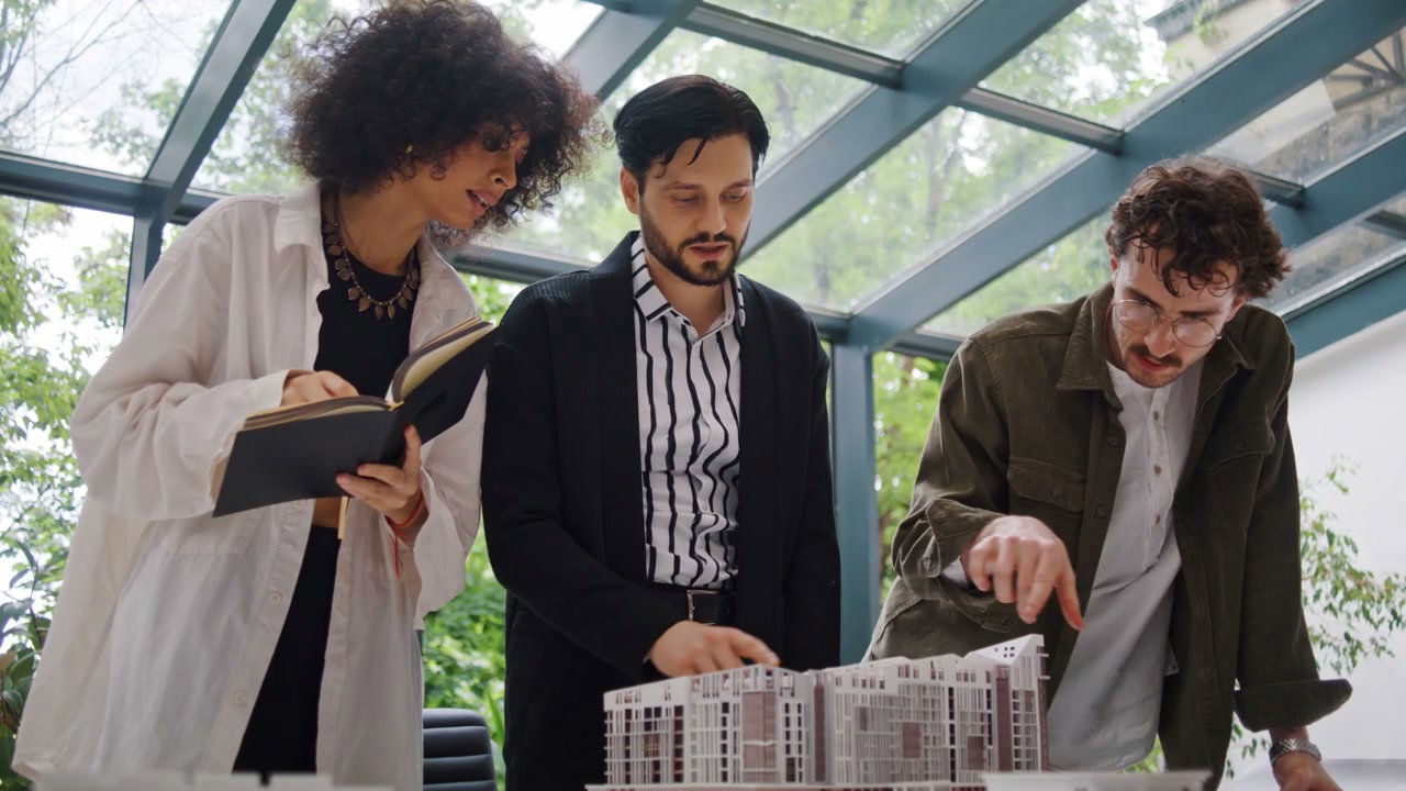 Three Architects Discussing Building Model