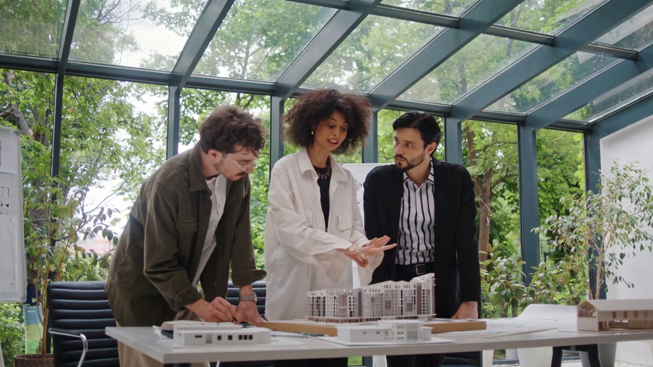 Architects Discussing Building Model in Modern Office