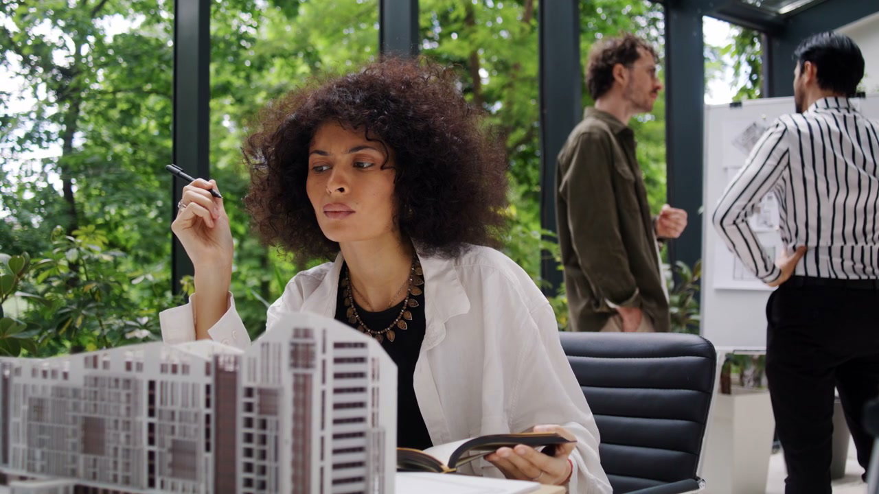 Woman Architect Examining Building Model