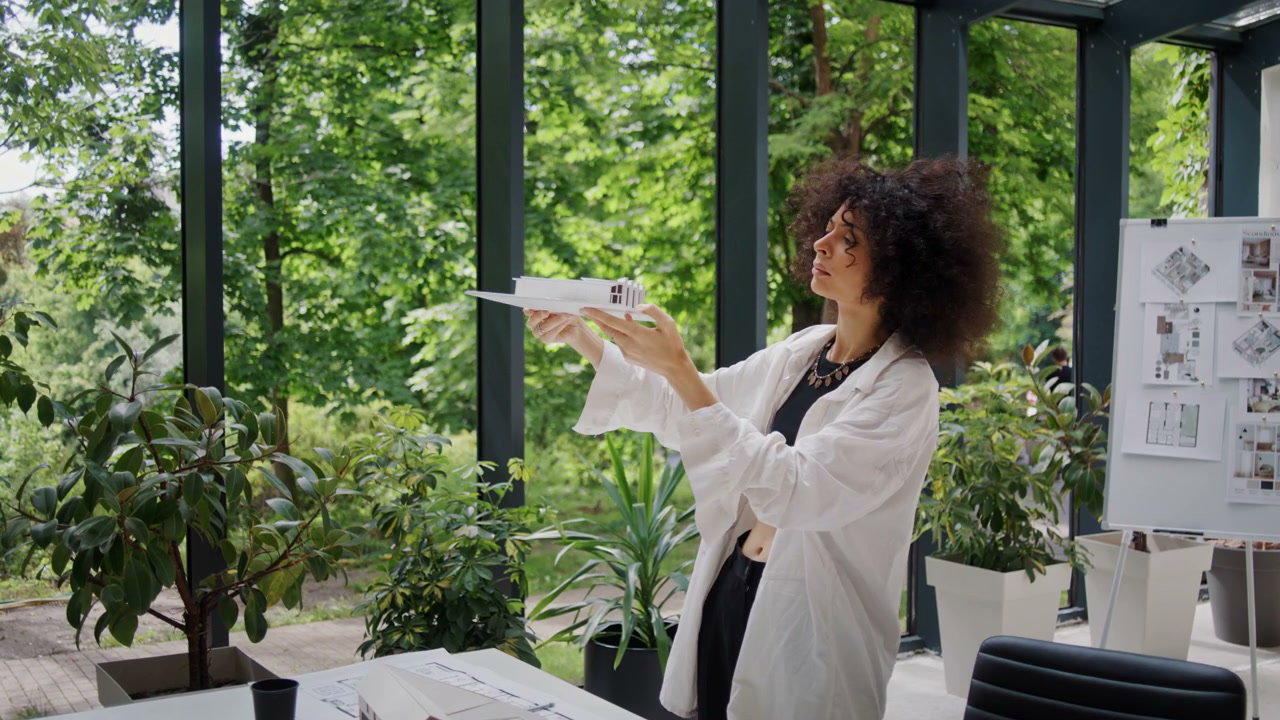 Woman Architect Examining Building Model