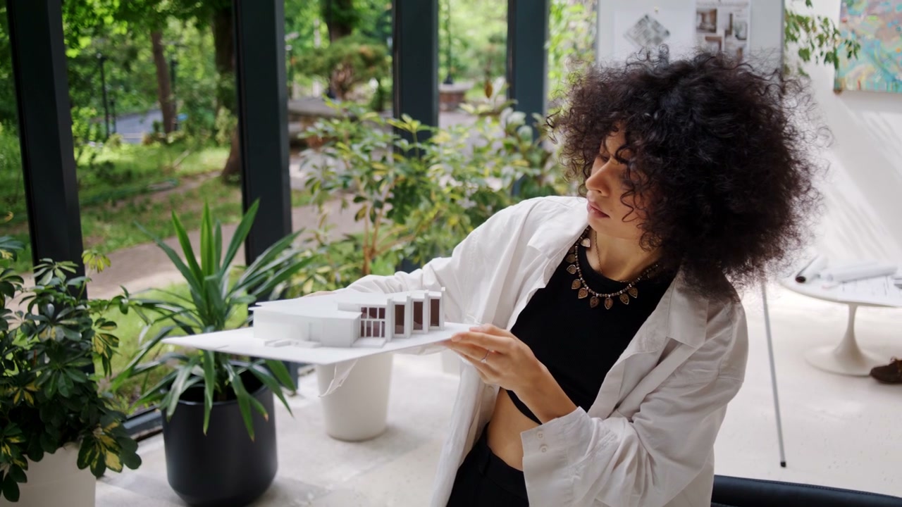 Woman Architect Examining House Model