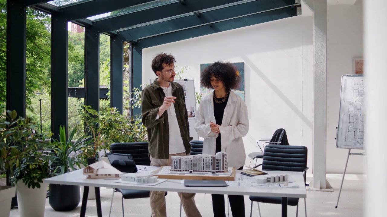 Architects Discussing Building Models in Office