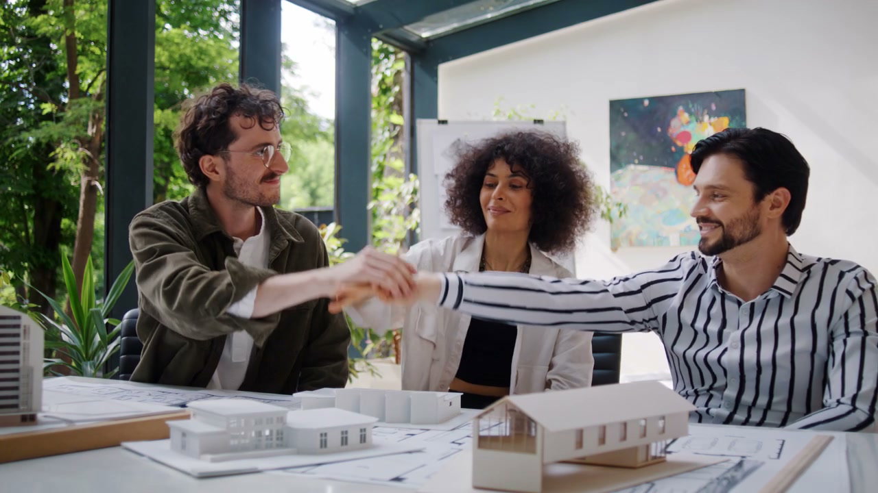 Team of Architects High-Fiving in Office