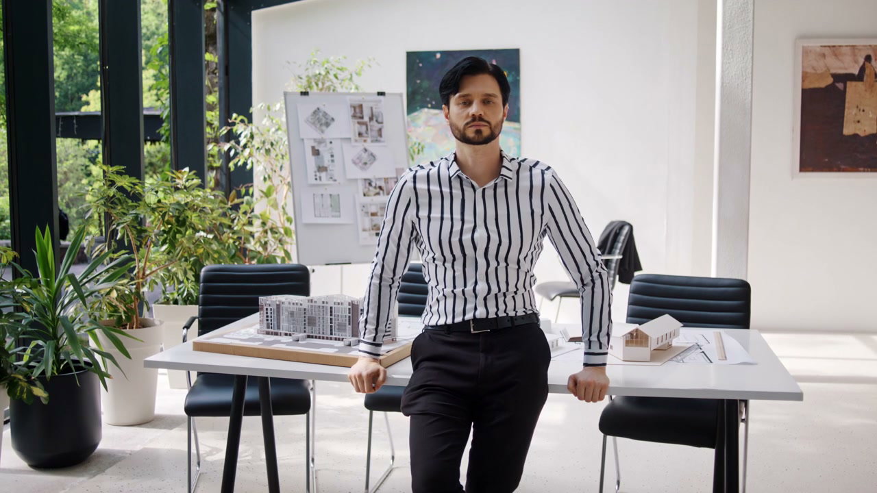 Architect Leaning on Conference Table in Office