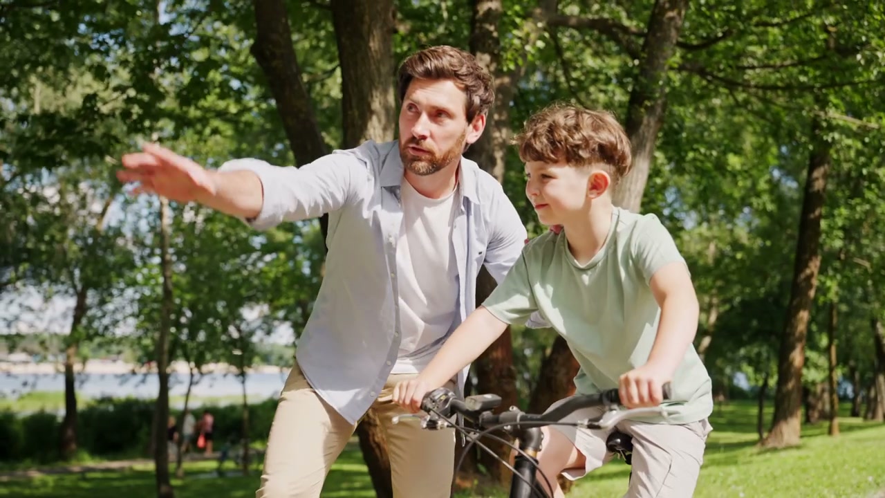 Father Teaching Son to Ride Bike in Park
