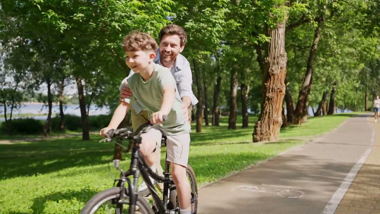 Father Teaching Son to Ride Bike in Park