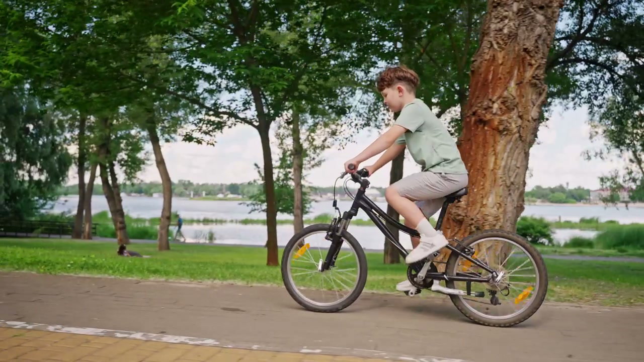 Boy Riding Bicycle on Park Path