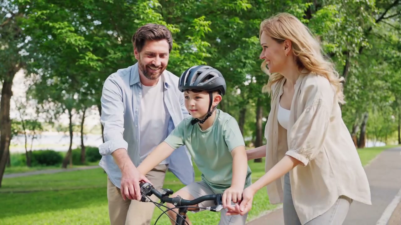 Parents Teaching Son to Ride Bike in Park