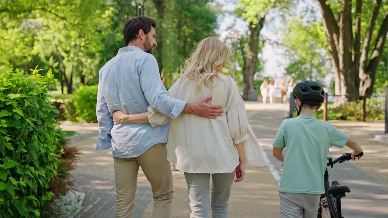 Family Walking in Park with Bicycle