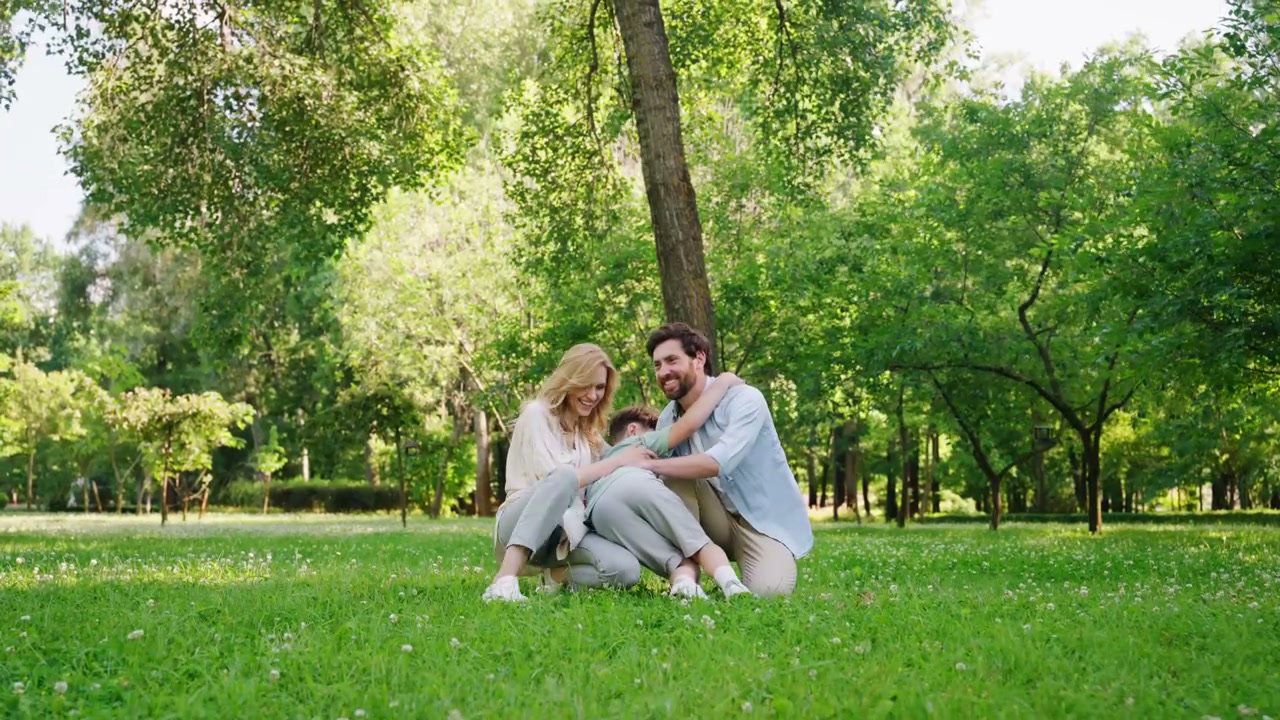 Family Hugging Son in a Sunny Park