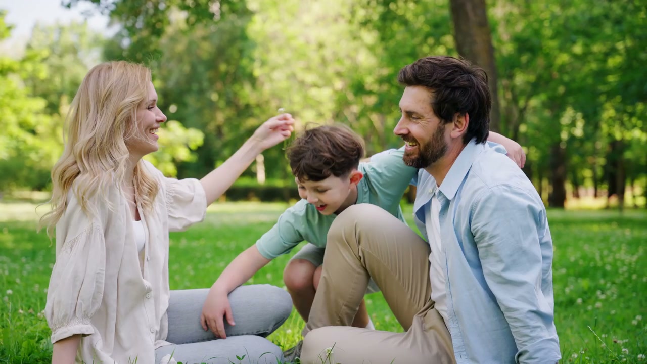 Happy Family Relaxing on Grass in a Park