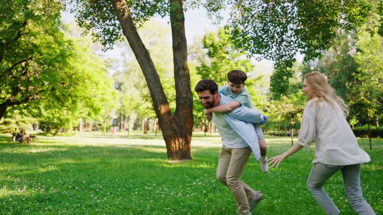 Happy Family Piggyback Ride in Park